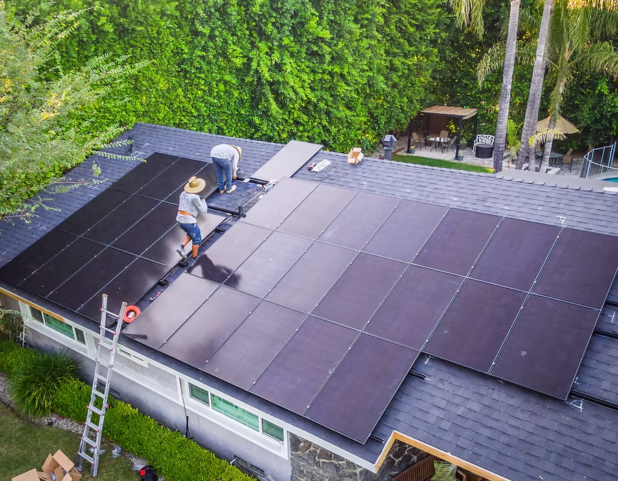 Luftaufnahme einer Photovoltaikanlage auf einem Hausdach während der Wartung